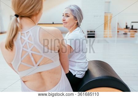 Pilates, Fitness, Sport, Training And People Concept - Woman Doing Exercises On Small Barrel.