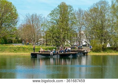 Britzer Garten, Berlin, Germany - April 16, 2020: Visitors Enjoying The Sunshine On The Lake Platfor