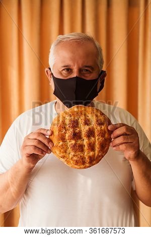 Man With Pide On His Hands On Ramadan 2020 Wearing A Protective Mask Against The Virus Covid-19. 
Ph