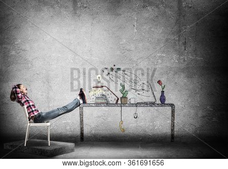 Young Happy Woman Relaxing In Room. Creative Freelance Designer Sitting On Chair And Putting Feets O
