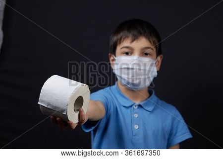 A Child In A Protective Mask Holding Toilet Paper Napkins