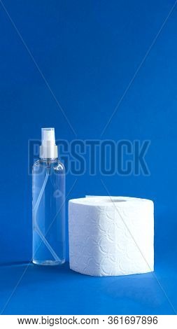 Bottle Of Anitizer And White Toilet Paper On The Blue Background