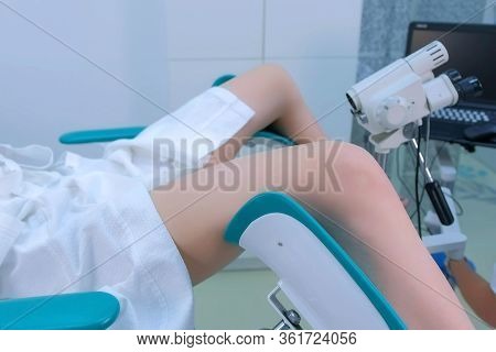 Patient And Doctor In Gynecological Office On Colposcopy Procedure, Side View, Legs Closeup. Doctor 