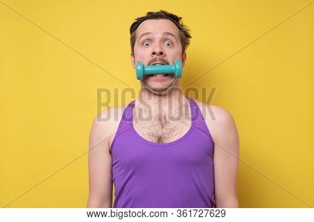 Young Sportive Man Holding A Dumbbell In Mouth