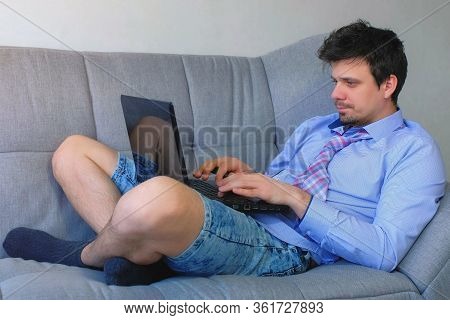 Freelancer Man Working Typing On Laptop At Home Sitting On Couch, Freelance Distant Work On Quaranti