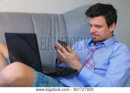 Freelancer Man Working Typing On Laptop At Home Sitting On Couch, Freelance Distant Work On Quaranti