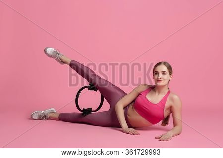 Wellness. Beautiful Young Female Athlete Practicing In Studio, Monochrome Pink Portrait. Sportive Fi