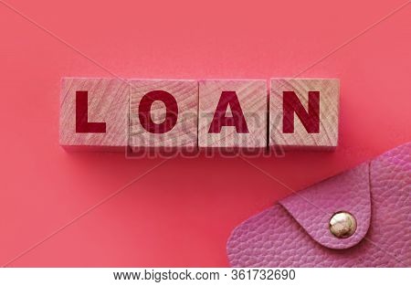 Wooden Blocks With The Text: Loan With Pink Leather Wallet Besides On Warm Pink Background. Finance 