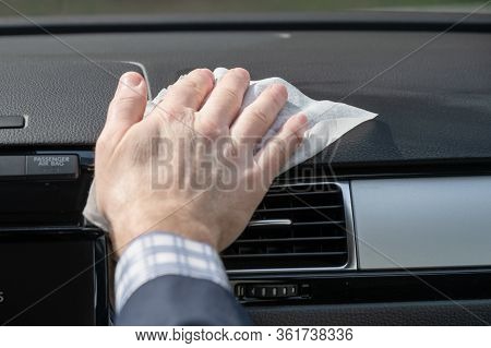 Middle Age Businessman In A Blue Suit Cleaning Front Dashboard Of A Car Using Antivirus Antibacteria