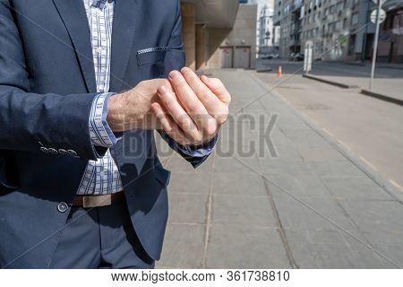 Businessman In A Blue Suit Using Small Portable Antibacterial Sanitizer Applying Antiseptic For Wash