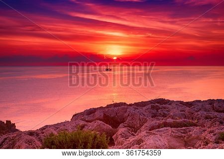 Beautiful Colorful Sunrise At The Sea With Dramatic Clouds, The Sailing Boat And Sun Shining