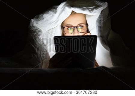 Woman In Glasses Lying In Bed Under The Blanket Using Tablet Late At Night, Can Not Sleep, Addict Ne