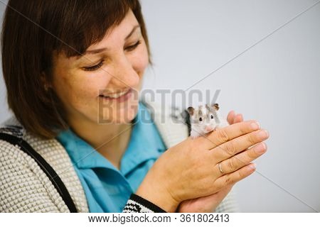 Girl Holds White Furry Little Mouse On White Background. Cute Young Mice In Hands Of Vet. Small Whit