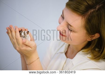 Girl Holds White Furry Little Mouse On White Background. Cute Young Mice In Hands Of Vet. Small Whit