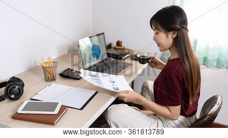 Attractive Young Beautiful Asian Woman Working With Laptop And Document While Sitting At The Indoors