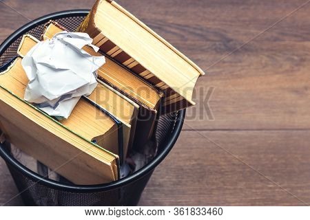 Books And Crumpled Paper In The Bin. Books That Do Not Read, Low-grade Literature, Copy Space_
