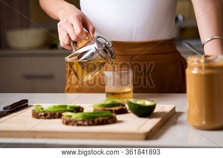 Woman Making Morning Tea To Have With Breakfast At Home
