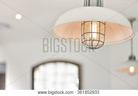 Light With A Round Plastic Cover Flashing With A Blurred Background Of A Room With White Walls