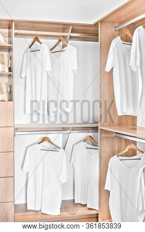 T-shirts Hanging On The Racks Closeup In A Modern Room With White Walls,  These T-shirts Are Collarl