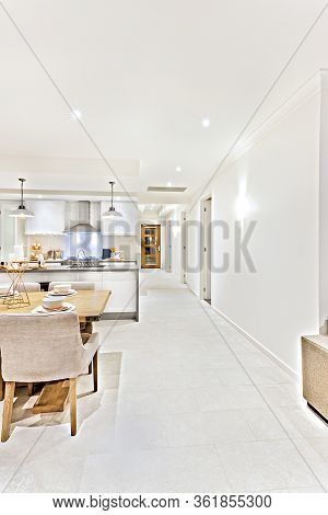 Modern Living Room Interior At Night With Flashing  Lights Through The Hallway Beside Dining Area An