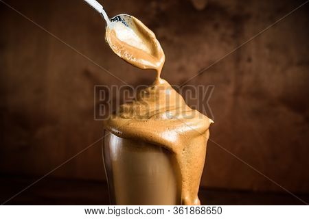 Cold Dalgon Coffee In Clear Glasses On A Dark Wooden Background. Foam From Sugar And Instant Coffee