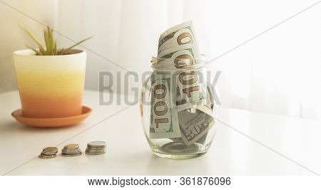 Many 100 Us Dollars Bank Notes In A Glass Jar Isolated On White Background