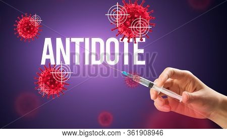 Close-up view of doctor's hand in a white glove holding syringe with ANTIDOTE inscription, coronavirus antidote concept