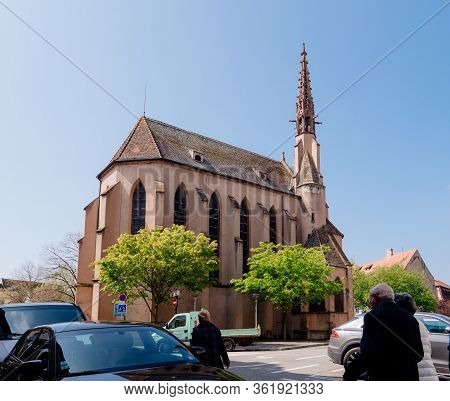 Selestat, France - Apr 15, 2019: Crowd Of People Walking Near The Protestant Church Of Selestat On A