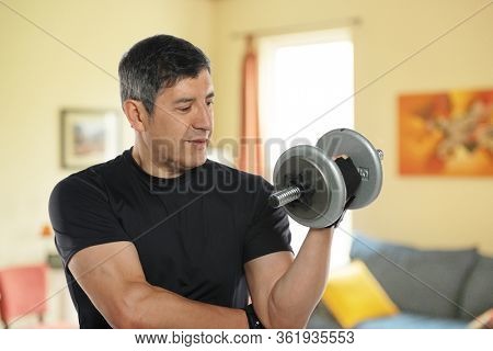 Mature man workingout at home in his livingroom