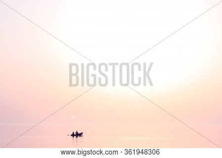 Sunset At Sea. Romantic Photo With The Sea Rolling In The Sky And The Couple In Love In A Boat. Pink