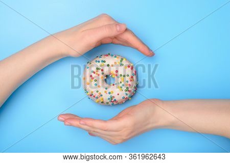 Perfect Food Creating Concept. Photo Of Tasty Donut With Colorful Sprinkles And Two Hands Making Roo