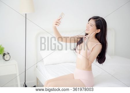 Beautiful Young Asian Woman Sexy In Underwear Talking A Selfie On Smartphone For Social Network In T
