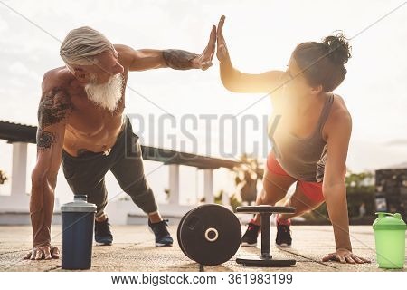 Fitness Couple Doing Push Ups Exercise Outdoor - Happy Athletes Making Workout Session At Sunset Out