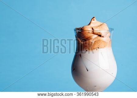 Glass Cup Of Whipped Dalgona Coffee On A Blue Background.