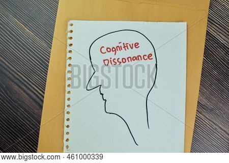 Concept Of Cognitive Dissonance Write On A Paper Book Isolated On Wooden Table.
