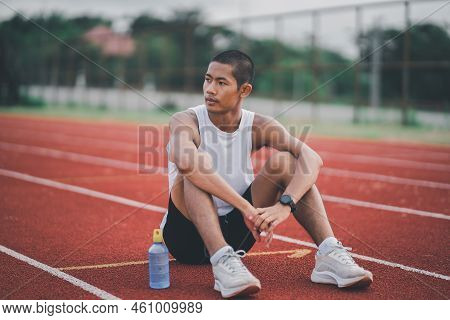 Athletes Runner Sport Man Resting Bottle Water Tired And Thirsty  Practicing On A Running Track At A