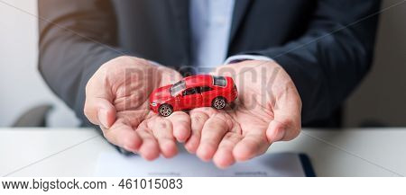 Businessman Hand Holding Red Car Toy With Vehicle Keyless, Pen And Contract Document. Buy And Sale, 