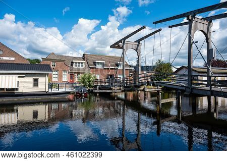 Hasselt, Overijssel, The Netherlands - 07 20 2022 - Wooden Old Bridge Over The Canal With Reflecting