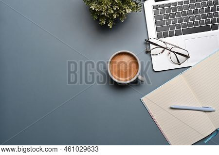 Above View Coffee Cup, Laptop Computer An Empt Notebook On Blue Background.