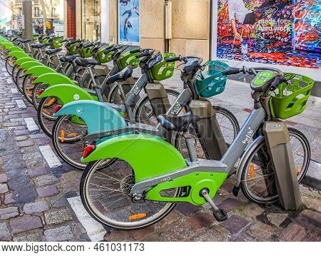 Paris, France - February 17, 2020. Electric Rental Bikes, Green And Gray, Locked On Their Chargers. 