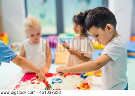 Relaxing Sensory Play With Moldable Kinetic Sand At Nursery School. Toddlers With Their Teacher Havi