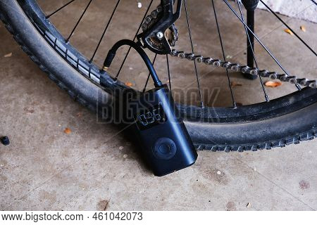 Process Of Inflating Bicycle Tire With Attached Electric Pump With A Digital Display Showing Pressur