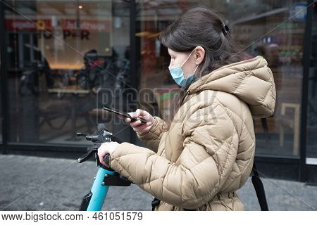 Brussels Belgium - 01.31.2022 A Young Woman In A Warm Down Jacket And A Mask