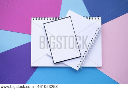 Stack Of Empty Blocks And Notebooks With Spiral. Multicilor Paper Background. Copy Space, Top View. 