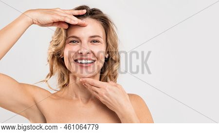 Facebuilding Concept. Happy Beautiful Middle Aged Woman Touching Chin And Forehead
