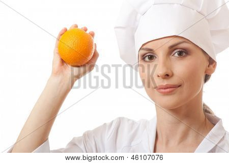 Smilende kvinde cook med orange, isoladed på hvid baggrund