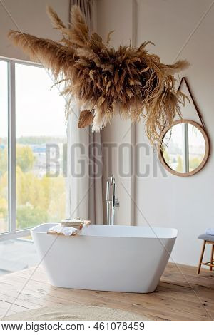 Comfortable Bright Bathroom With A Boho-chic Interior Design, A Free-standing White Bath Against The