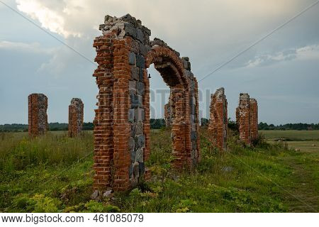 The Remains Of A Stone Column From An Old Building In The Middle Of A Field On A Sunny Spring Day. C