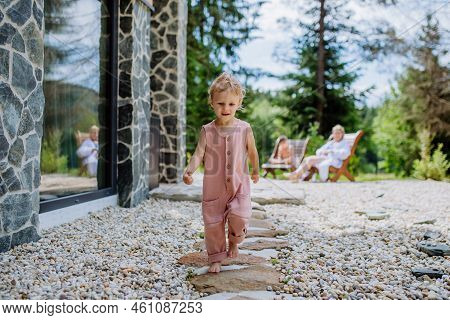 Little Girl Walking Barefoot Near The Forest Cotage, Weekend Time During Summer Day.