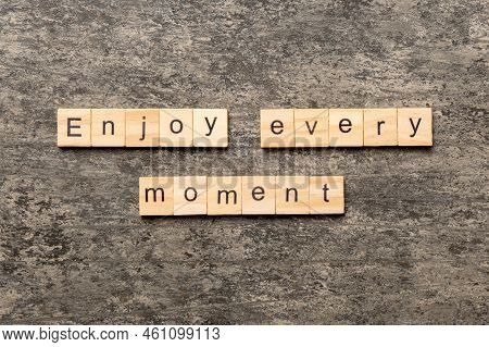 Enjoy Every Moment Word Written On Wood Block. Enjoy Every Moment Text On Cement Table For Your Desi